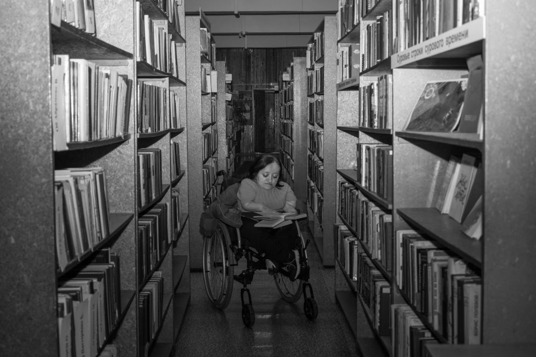 Оля выбирает книги в библиотеке