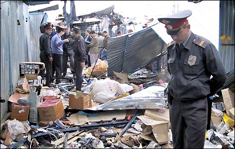 Investigators work at the site of a bomb explosion at a market